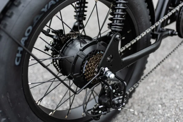Zoom sur la roue arrière d'un fatbike électrique avec pneu large Chao Yang, cassette Shimano et dérailleur Tourney.